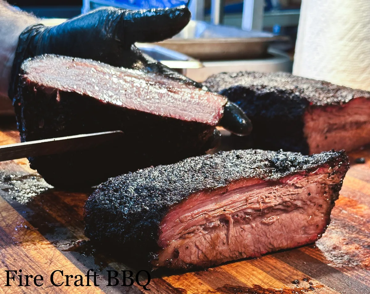 Sliced smoked brisket showing its bark and smoke ring
