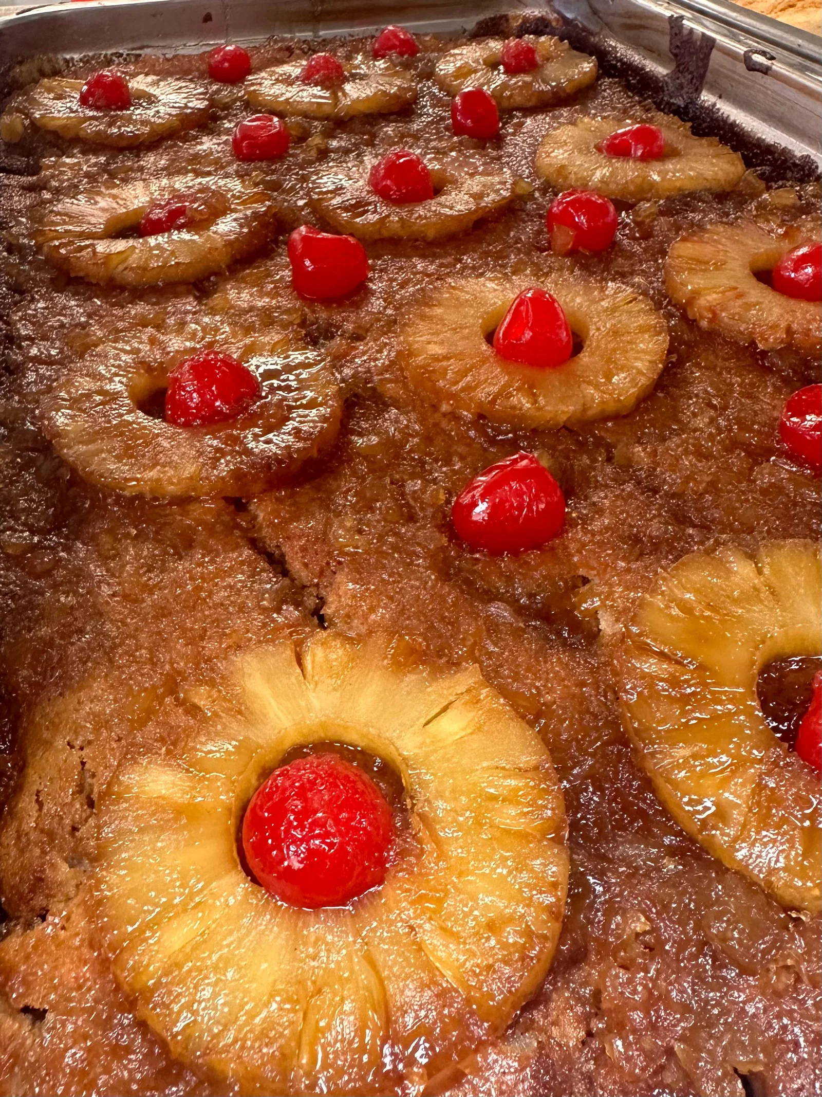 A pan of baked dessert topped with pineapple rings and cherries
