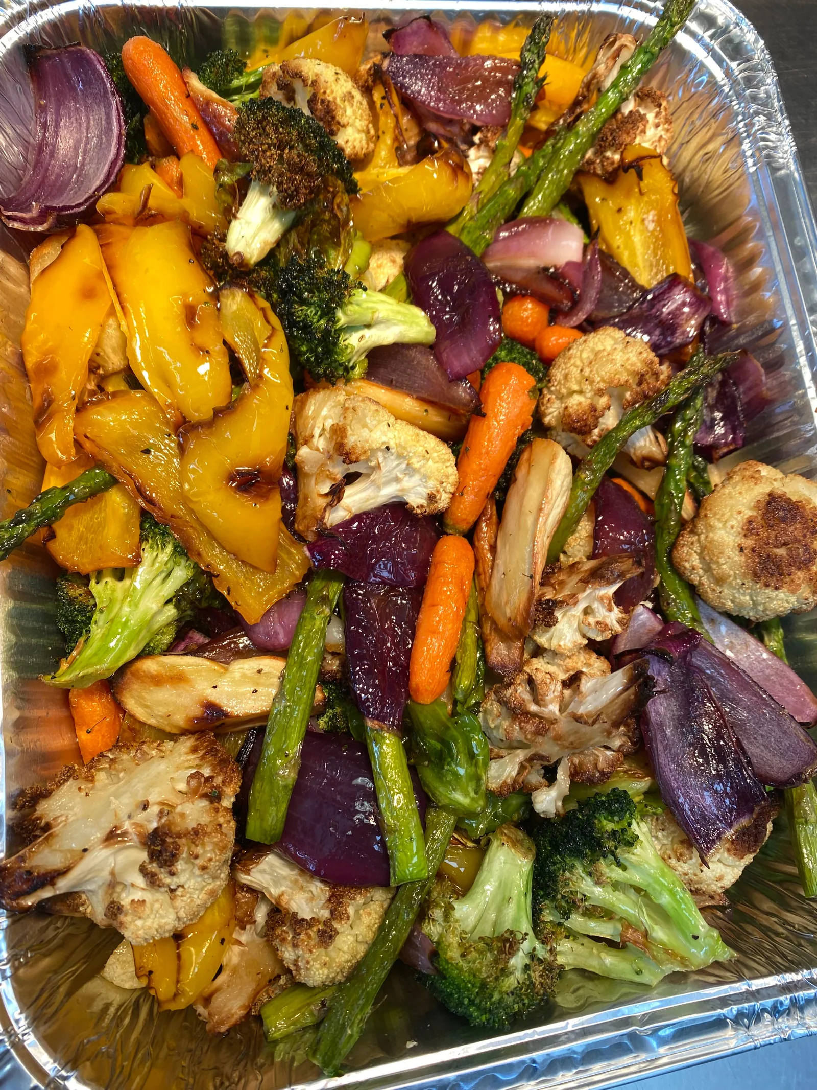 A tray of roasted broccoli, cauliflower, carrots, peppers and onions